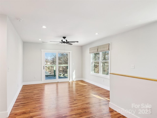 spare room with ceiling fan, a wealth of natural light, and hardwood / wood-style floors