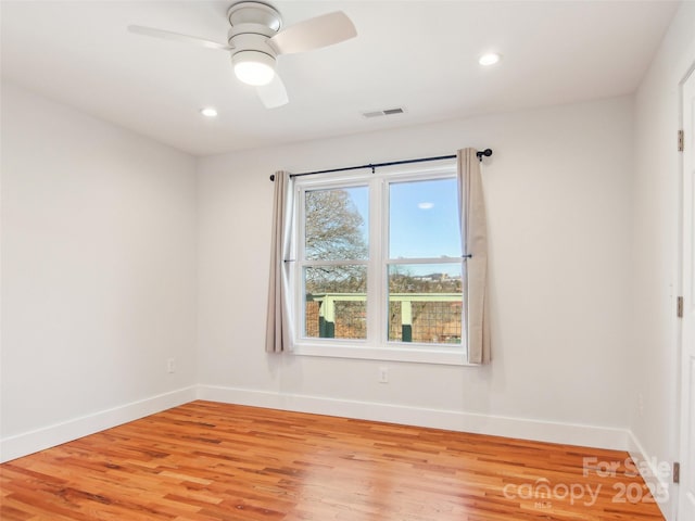 spare room with ceiling fan and light wood-type flooring