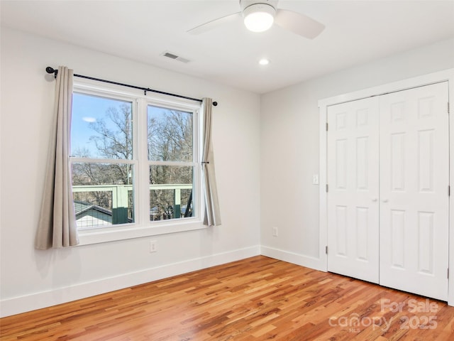 unfurnished bedroom with hardwood / wood-style floors, a closet, and ceiling fan