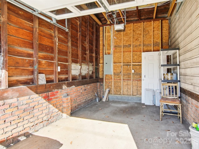 garage with a garage door opener and electric panel