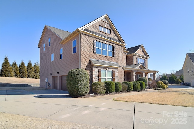 view of front of house featuring a garage, concrete driveway, and brick siding