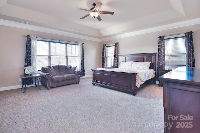 carpeted bedroom featuring a raised ceiling, crown molding, and multiple windows