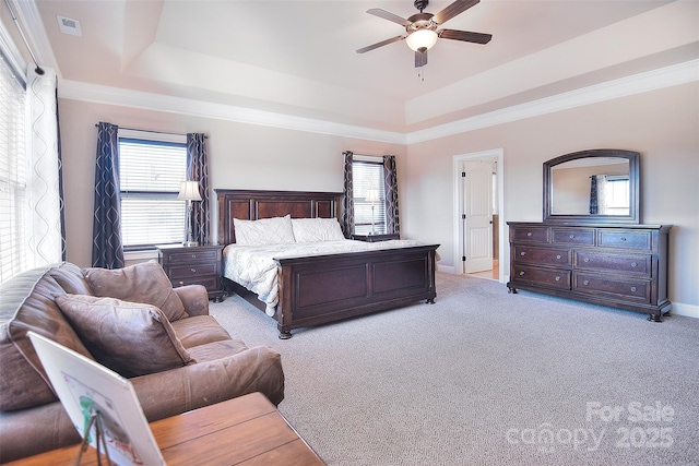 bedroom featuring a raised ceiling, light carpet, and baseboards