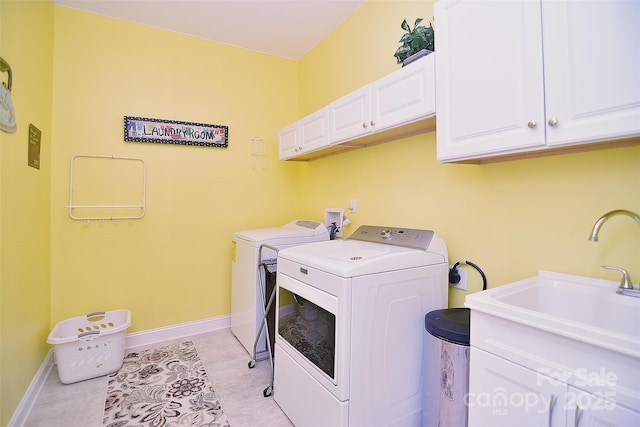 laundry area with light tile patterned flooring, cabinets, washer and clothes dryer, and sink