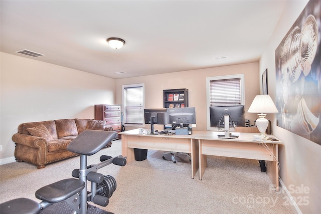 carpeted office featuring visible vents and baseboards