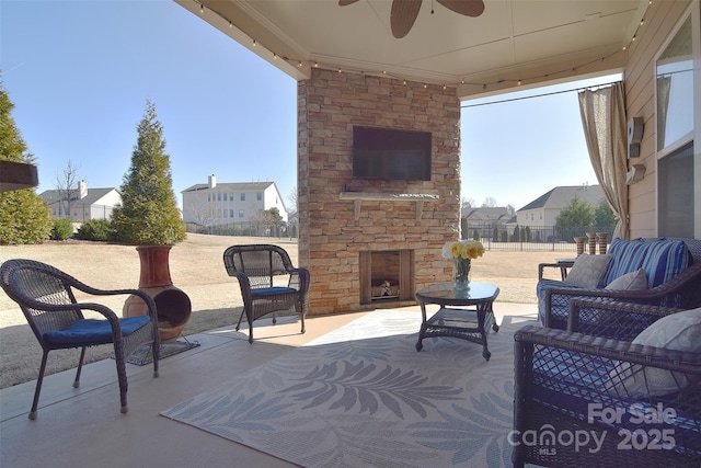 view of patio with ceiling fan and an outdoor living space with a fireplace