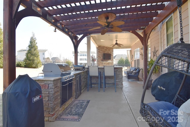 view of patio / terrace featuring ceiling fan, exterior kitchen, a grill, and a pergola