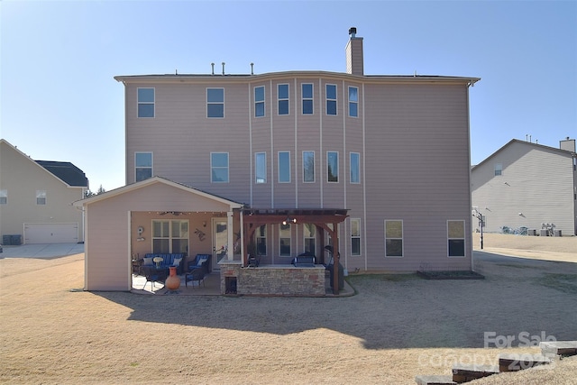 rear view of house with a chimney, a ceiling fan, and a patio