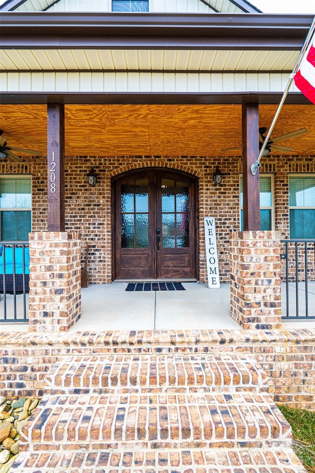 property entrance with covered porch and french doors