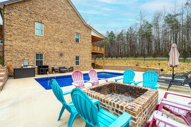 view of pool with an outdoor fire pit and a patio