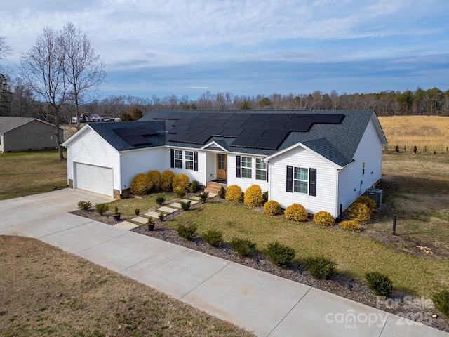 ranch-style home featuring a front yard, central AC unit, solar panels, and a garage