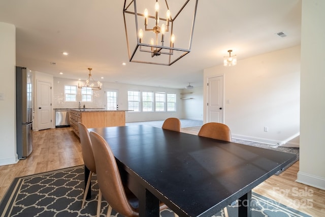 dining room featuring light hardwood / wood-style flooring, a chandelier, and sink