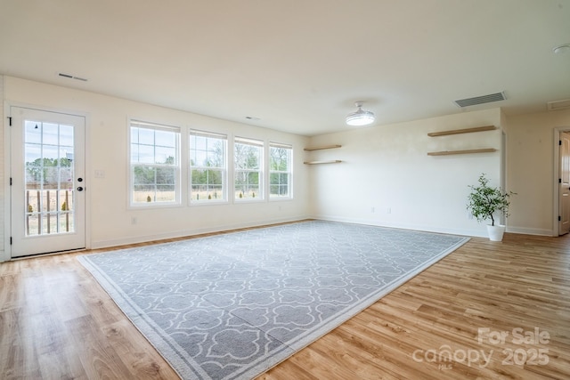 unfurnished living room featuring hardwood / wood-style floors and a wealth of natural light