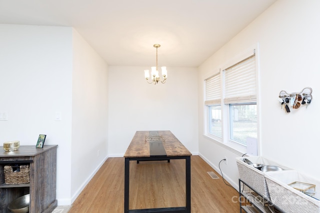 dining area with a notable chandelier and light wood-type flooring