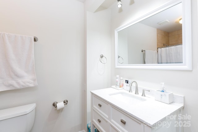 bathroom featuring vanity, a shower with shower curtain, and toilet