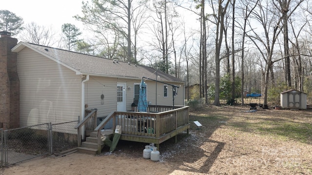 back of house with a wooden deck and a storage unit