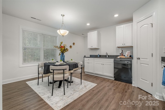 interior space featuring pendant lighting, sink, dishwasher, white cabinets, and dark hardwood / wood-style flooring