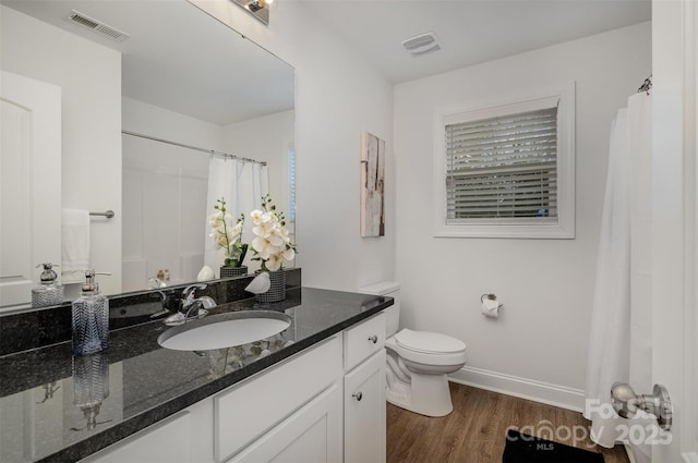 bathroom featuring vanity, hardwood / wood-style floors, and toilet