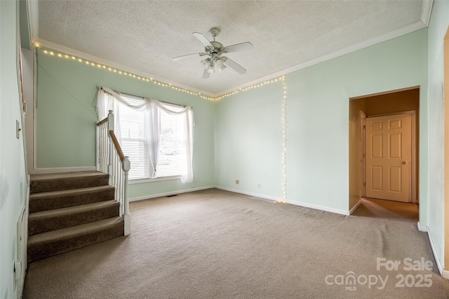 carpeted spare room with crown molding, ceiling fan, and a textured ceiling