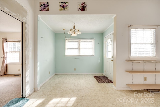 foyer entrance with crown molding, a chandelier, and a textured ceiling