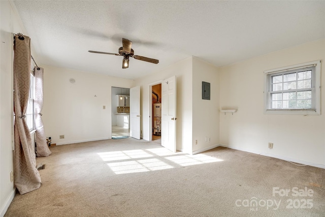 carpeted spare room with ceiling fan, electric panel, water heater, and a textured ceiling