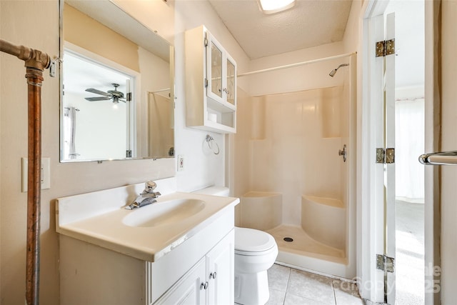 bathroom with walk in shower, vanity, toilet, and tile patterned flooring