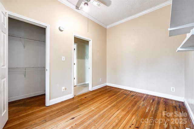 unfurnished bedroom with ceiling fan, ornamental molding, a textured ceiling, a closet, and light wood-type flooring