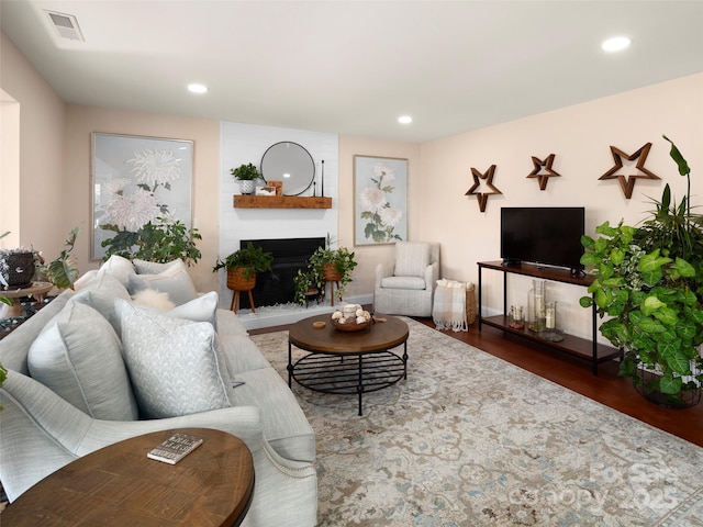 living room with dark hardwood / wood-style flooring and a large fireplace