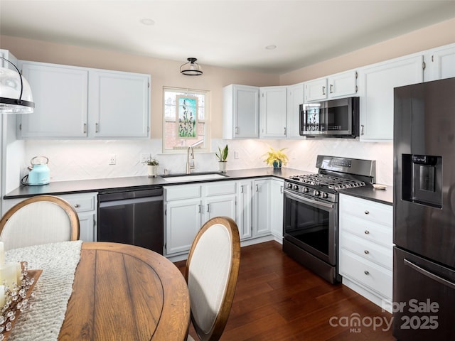 kitchen featuring appliances with stainless steel finishes, sink, white cabinets, and dark hardwood / wood-style floors