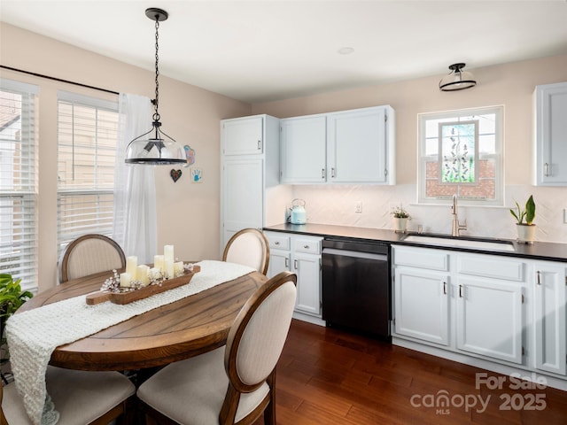 kitchen with dark hardwood / wood-style floors, pendant lighting, white cabinetry, dishwasher, and sink