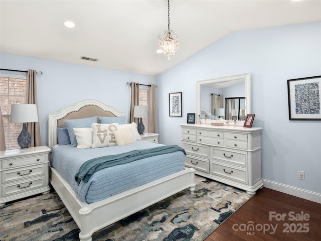 bedroom with an inviting chandelier, dark hardwood / wood-style floors, and vaulted ceiling