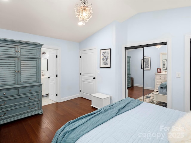 bedroom featuring dark hardwood / wood-style floors, connected bathroom, lofted ceiling, a notable chandelier, and a closet