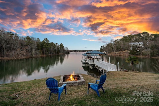 dock area featuring a gazebo, a water view, a lawn, and a fire pit