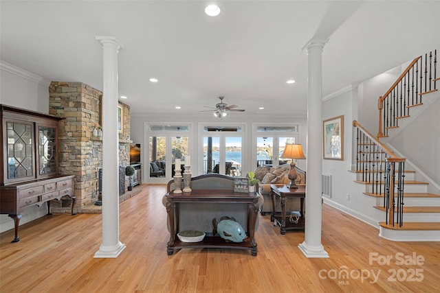 living room with ornamental molding and decorative columns