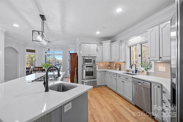 kitchen featuring gray cabinets, appliances with stainless steel finishes, pendant lighting, sink, and backsplash