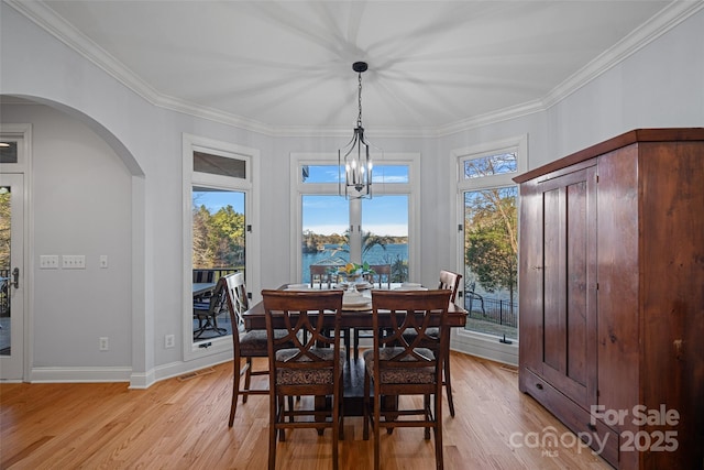 dining area featuring ornamental molding and light wood-type flooring