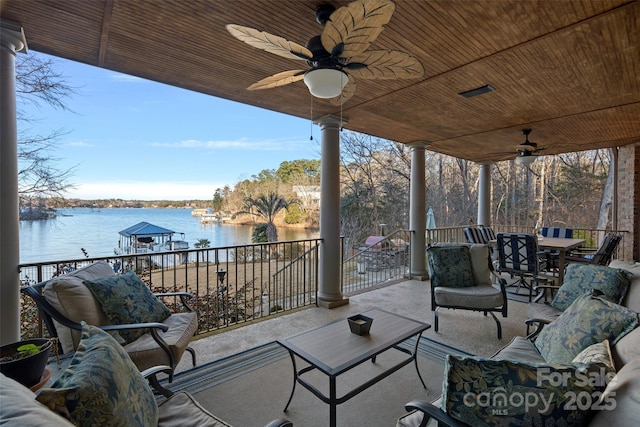 view of patio featuring a water view, ceiling fan, and an outdoor living space