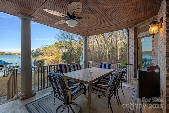 deck with a water view and ceiling fan