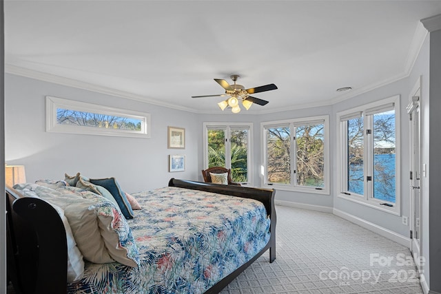 carpeted bedroom with multiple windows, crown molding, and ceiling fan