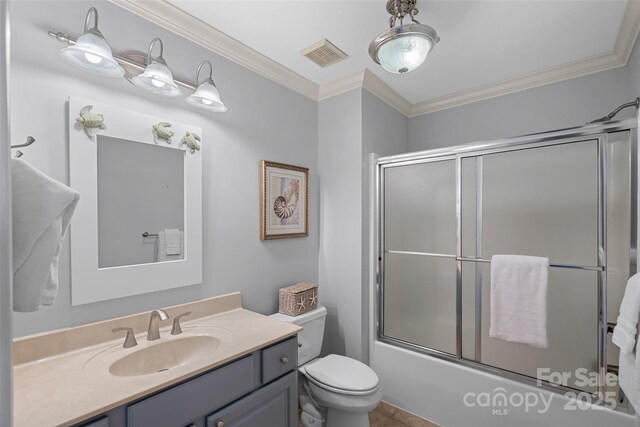 full bathroom featuring tile patterned floors, toilet, shower / bath combination with glass door, ornamental molding, and vanity