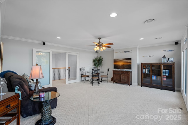 sitting room with crown molding, light colored carpet, and ceiling fan