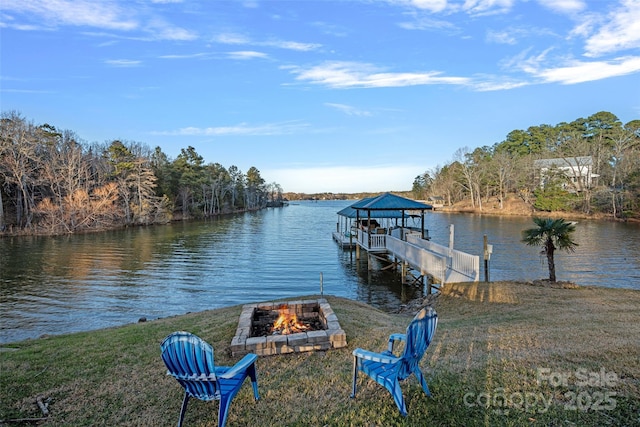 dock area featuring a lawn, a water view, and an outdoor fire pit