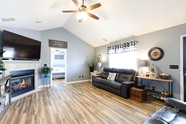 living room featuring vaulted ceiling, ceiling fan, and light hardwood / wood-style floors