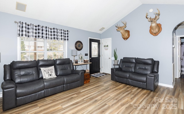 living room featuring hardwood / wood-style flooring and vaulted ceiling