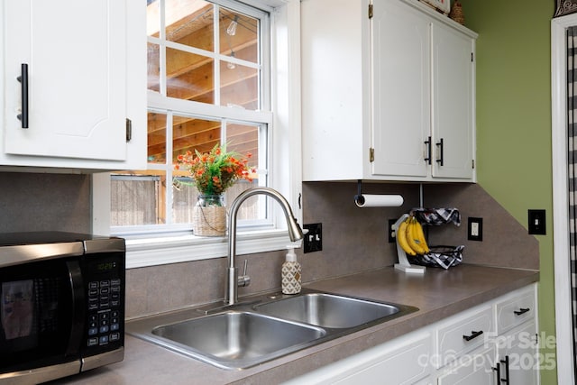 kitchen featuring white cabinetry, sink, and decorative backsplash