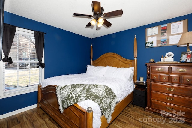 bedroom with ceiling fan, baseboards, and wood finished floors