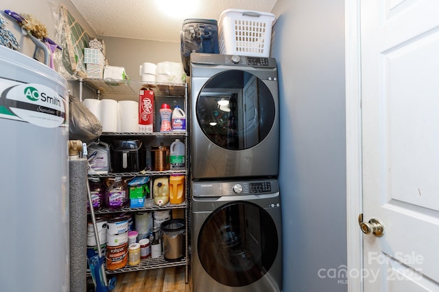 clothes washing area with a textured ceiling, laundry area, wood finished floors, and stacked washer and clothes dryer