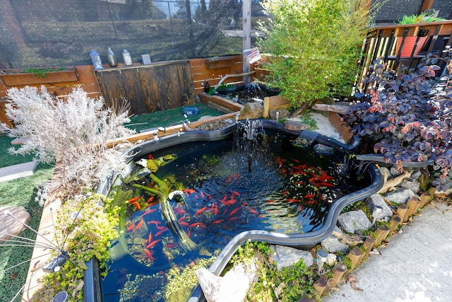 exterior space with a jacuzzi and a small pond