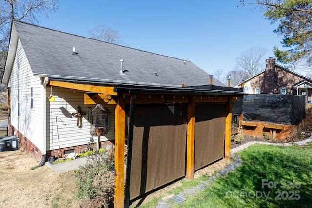 back of property featuring a shingled roof and crawl space