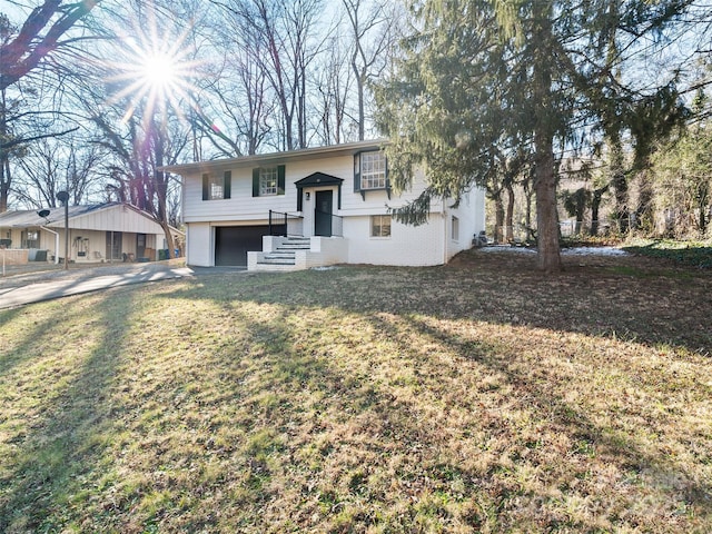 raised ranch with a garage and a front yard